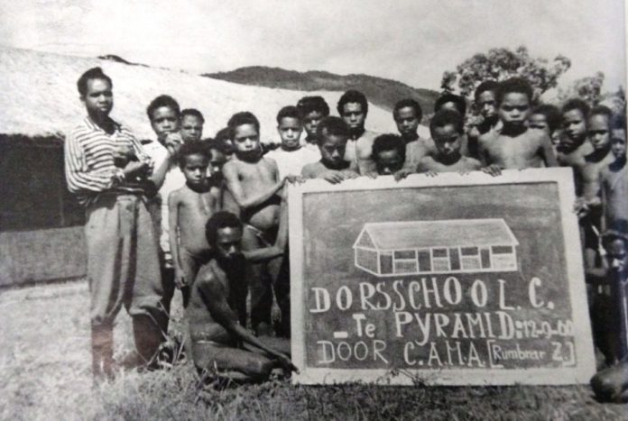 Anak-anak Pyramid bersama pengajarnya di depan sekolah mereka. Foto: Majalah Triton No. 2 Februari 1961, dokumentasi Perpustakaan Universitas Leiden, Belanda.